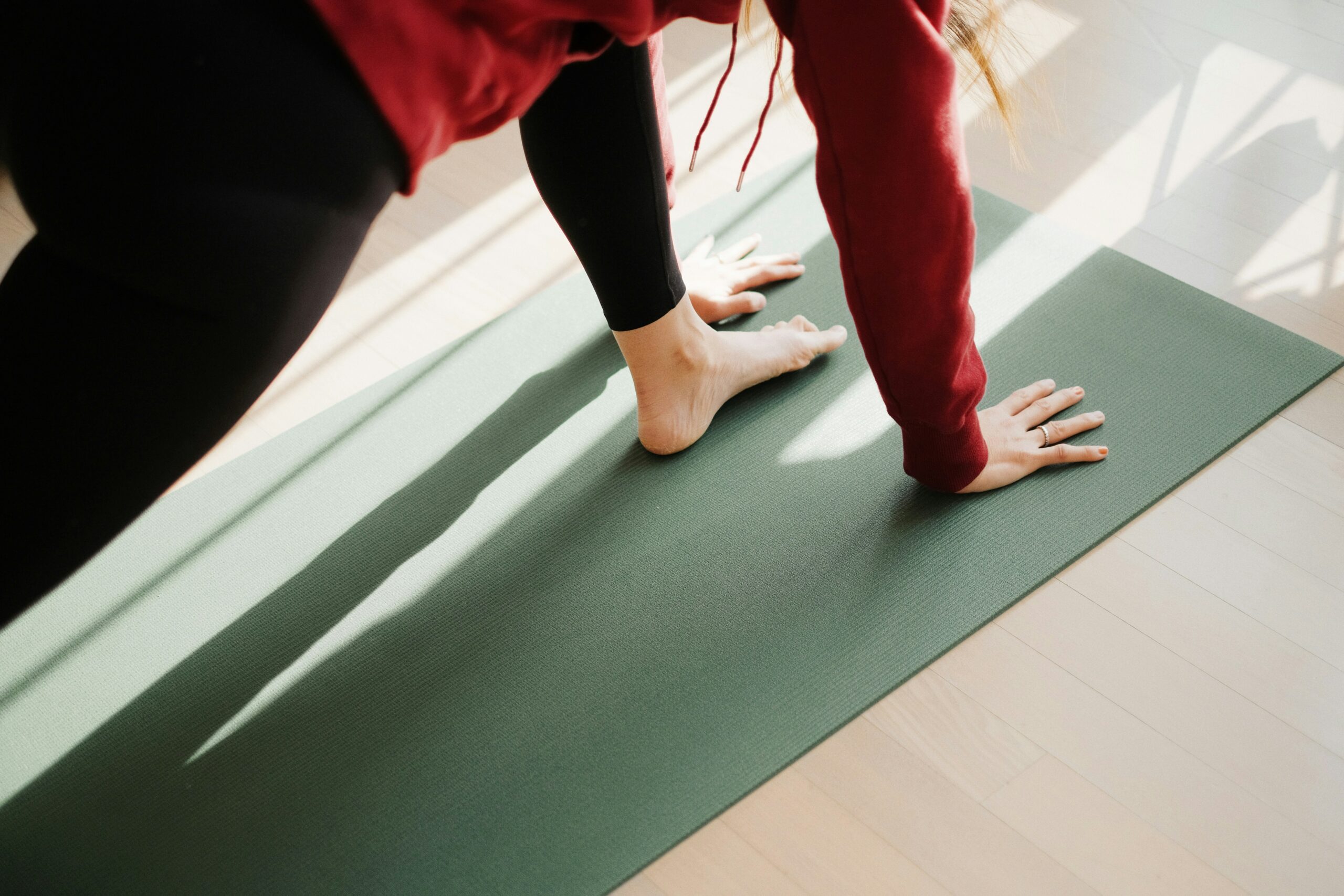 Personne debout sur un tapis de yoga, illustrant le choix du meilleur tapis pour débutant